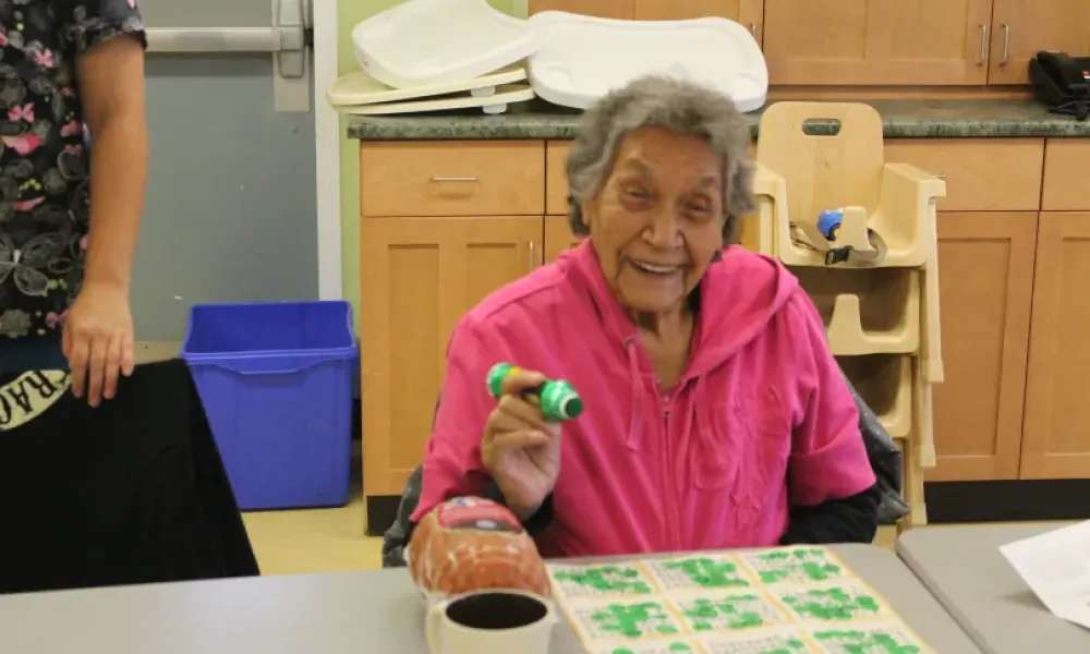 Elderly person smiling while playing bingo