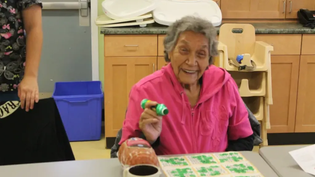 Elderly person smiling while playing bingo